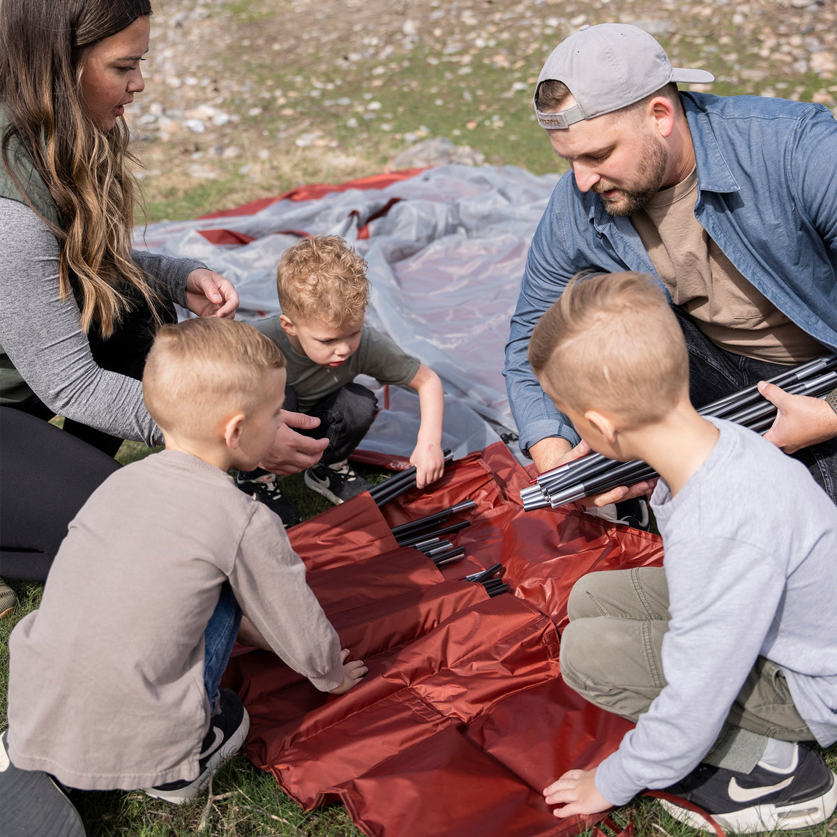 Family unpacking the Klymit Cross Canyon 6 Tent on its mat