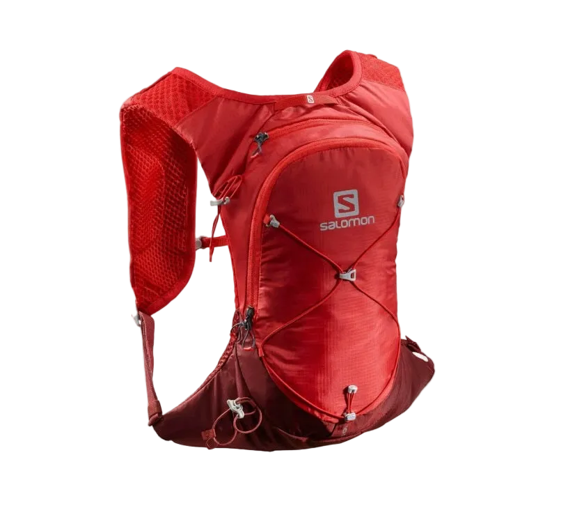 A red Salomon running backpack shown on a plain white background. The backpack features a breathable mesh back panel, multiple zippered compartments, and the Salomon logo on the front.